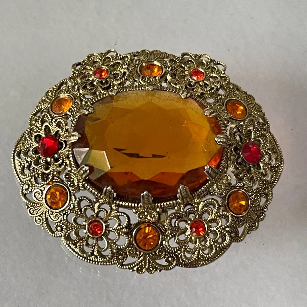Vintage West Germany brooch featuring a large amber topaz glass filigree gold